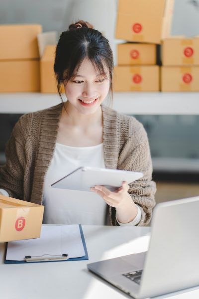 Portrait of a Small Business Startup, SME Owner, Female Entrepreneur work on parcel boxes Receipts a